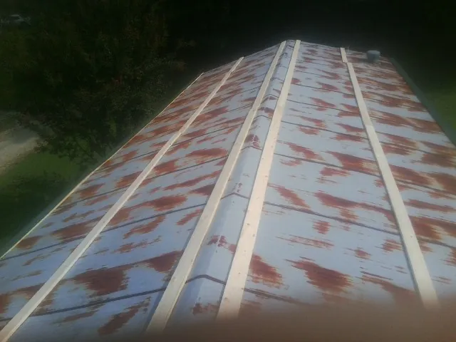 Rusted metal roof panels with new wood purlins before replacement — Storm Damage Roof Repair in Oak City by Roofing Brothers